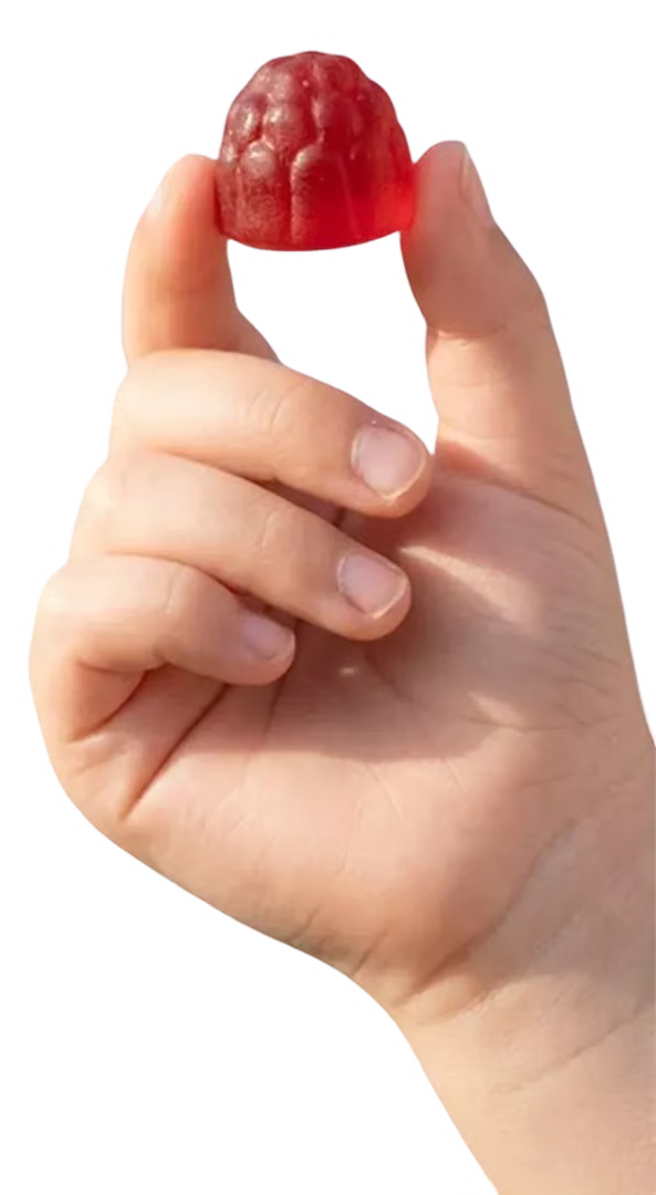 Hand holding a red berry-shaped gummy